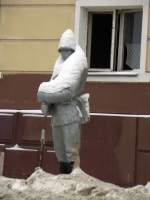 Скульптура военного у заброшенного здания.